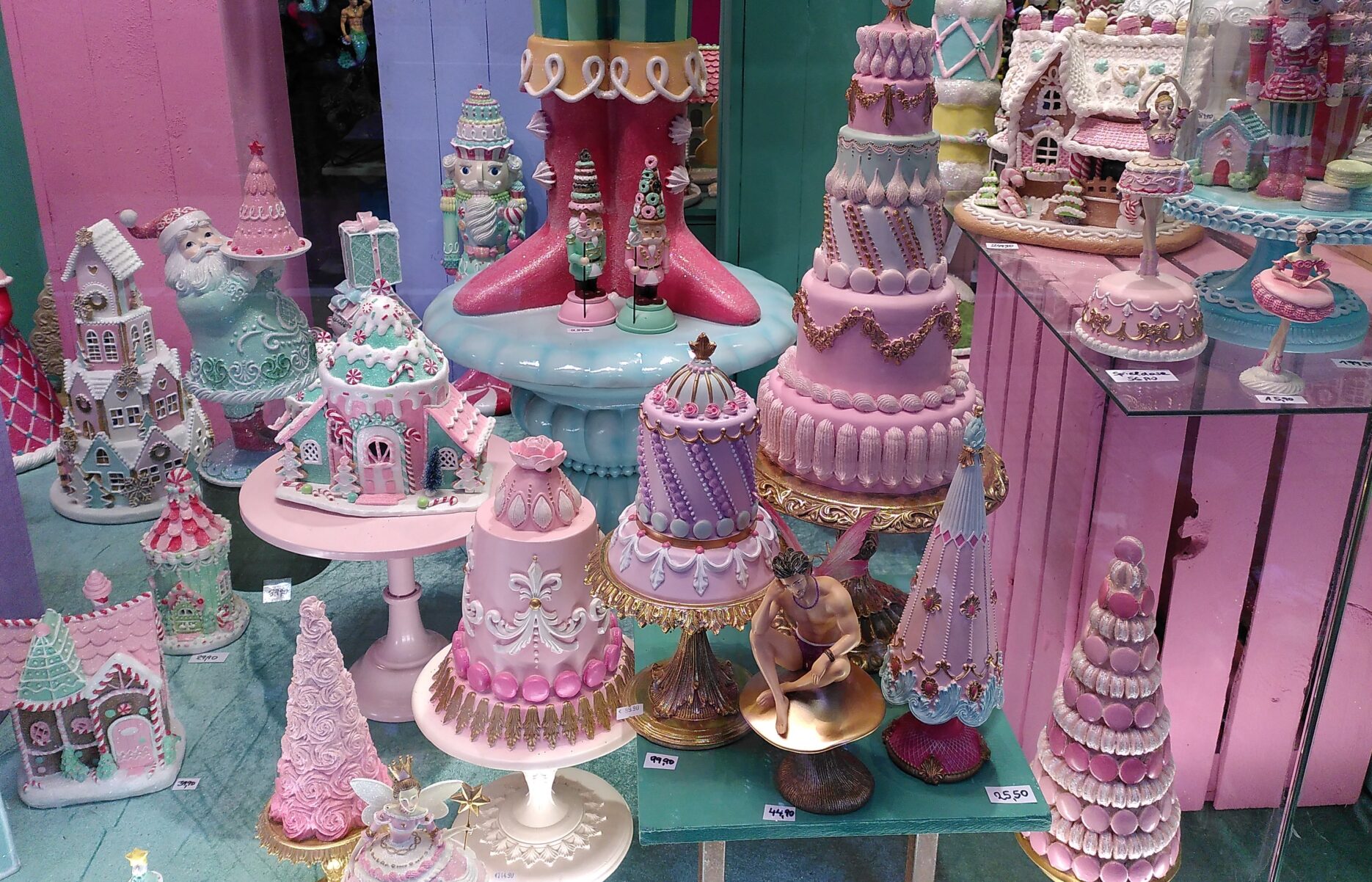 Ein Schaufenster mit bonbonbunten Törtchen und Nussknackerfüßen in rosa, lila und hellblau