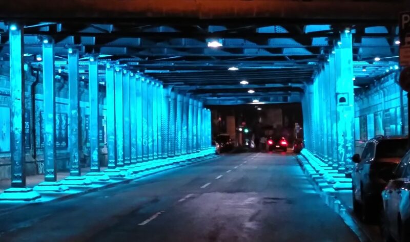 Innenstädtischer Tunnel unter Eisenbahnbrücke, blau beleuchtet